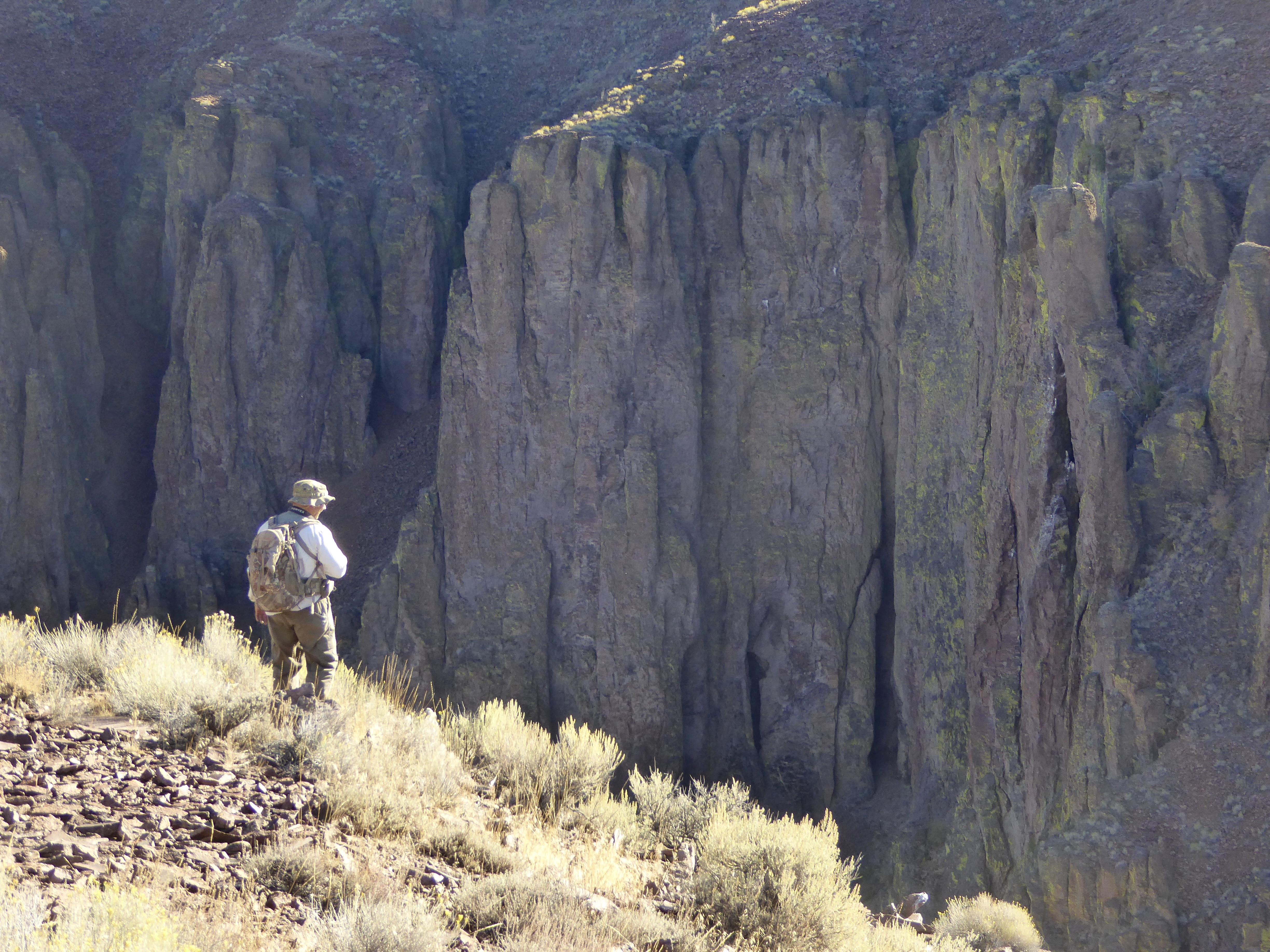 Man standing near cliffs in the Owyhees.